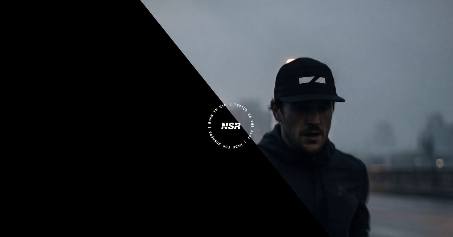 Person wearing a cap with a logo on a dark background